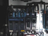 Close-up of left breaker section — 3-pole 70A breaker in OFF position and two single-pole 15A breakers in ON position