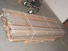 Pallet of Tucker Mfg US Military wood ridge beam tent poles strapped together in warehouse storage