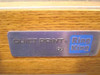 Ring King Quiet Print nameplate close-up on oak wood side panel, brushed metal badge reading 'QUIET PRINT by Ring King'