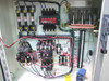 Close-up of Leybold-Heraeus enclosure interior showing blade fuse holders, motor contactors, wiring, terminal blocks, and blue timer relay