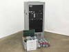 Advanced Microtechnology rack mount burn-in system full front view with floor cabinet and loose PCBs and accessories laid out in front