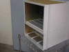 Nortel Passport 6480 NTJS61BA chassis — left-side angle view showing empty card cage upper section and two power supply bay guide rails in lower section, sitting on wire shelf