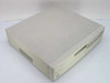 AST Bravo MS P/100 desktop computer front-left view showing beige case with floppy and CD-ROM drives, yellowed top surface with dust