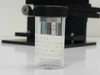 Rolyn Germany 10x N.A. 0.30 mounted achromat objective stored in its protective clear plastic vial — label shows X-10, FL-16.0, WD-6.0 specifications