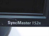 Close-up of Samsung SyncMaster 152N model name badge on lower bezel, showing light surface marks on the plastic bezel