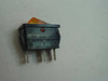 Idec Izumi C1403FQ illuminated rocker switch – rear/bottom view showing three solder pin terminals and label reading IDEC IZUMI CORP, ARCOLECTRIC ENGLAND
