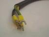 Close-up of wiring harness end showing black and green/yellow wires terminated with yellow insulated ring/spade lug connectors