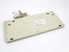 DEC RT101+ keyboard bottom view showing label, four corner feet, folded tilt legs, and coiled cable
