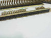 Underside/rear view of PBX rackmount connector block showing mounting rail, screw holes, and connector pin holes along bottom edge