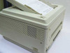 Panasonic KX-P4410 laser printer right-side and rear view showing ventilation grilles and paper output tray with printed page