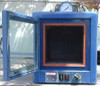 Benchtop vacuum oven shown with door open, revealing orange-gasketed interior chamber, front-panel rocker switch and rotary temperature knob, and top-mounted analog pressure gauge