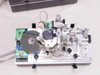 Lotus Technologies 7100 CSS module – interior view with enclosure removed showing hard disk drive under test, spindle motor assembly, optical encoder, PCB with components, and gaging mechanism