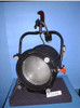 Strand Century 3501TV Castor 270 2000W Fresnel spotlight — three-quarter front view showing Fresnel lens, black housing, yoke with handle, orange adjustment knob, and white power lead