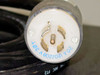 Close-up of locking power plug end showing 20A 120/208V 3-pole markings stamped in blue on white connector body