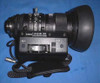 Canon J15X9.5 B4 KRS broadcast lens detail — front three-quarter view showing zoom/focus rings, Canon model label (J15x9.5B4 KRS, DXC-M3/DXC-6000), W/T zoom rocker, iris control, lens hood, and 6-pin cable connector