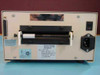 Microcom M-410 8 MedPlus thermal label printer — rear view showing parallel DB25 port, paper platen roller, IEC power inlet, power switch, and Microcom Corporation rating label