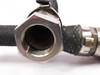 Close-up of JIC female NPT hex nut fitting end on stainless steel braided compressor discharge hose showing threaded interior