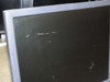 Close-up of LCD monitor screen showing multiple hairline scratches and surface imperfections on panel