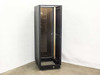 Industrial rackmount enclosure cabinet – front three-quarter view with smoked glass door open, showing interior rack space and casters