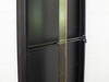 Rackmount cabinet interior detail – close-up of adjustable rack rail with punched holes and latch hardware on front door