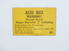 Close-up of yellow ACID MIX warning label on lid – HCL hazard notice with safety instructions