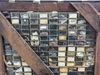 Close-up of parts bins on front face of crate showing small plastic and metal drawers filled with assorted hardware, springs, screws, and mechanical parts with handwritten labels