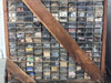 Side face of parts bin crate showing rows of labeled drawers with lenses, bushings, screws, rubber parts, and miscellaneous small hardware