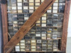 Detail of parts bin section showing drawers with handwritten labels, small gears, o-rings, and flat metal parts visible through clear plastic fronts
