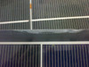 Close-up of Solopower SFX1-35 panel surface showing lifting and peeling of the clear backing layer between cell rows