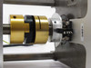 Close-up of brass torque limiter coupling and silver output hub assembly between the indexer and end plate