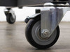 Close-up of Shepherd brand swivel caster with rubber wheel on industrial roll storage cart base