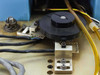 Laurier HA245 die loader – close-up of rotary actuator or indexing mechanism with black disc, precision slide, and mounting hardware