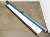 Large manual pull-down projection screen unrolled on floor showing white screen surface and blue cylindrical roller housing
