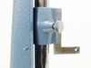 Close-up of microscope stand sliding carriage with knurled locking knob and L-bracket mounting arm on chrome rail