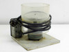Unbranded spin coater spinner rear/side view showing motor housing, power cord, and clear cylindrical bowl on base plate