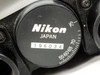 Close-up of Nikon Japan serial number label and interpupillary adjustment scale dial (55–70° range visible)