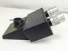 Side profile of binocular microscope head block showing angled body, eyepiece tubes, and swivel photo port