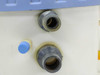 Close-up of Norpak filter housing side-mount gray PVC threaded fittings and blue valve cap detail