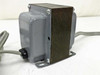 Unbranded 120V isolation transformer — left-side view showing laminated core stack, gray metal side panel, black terminal fitting, and output cable