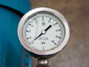 Close-up of 0-100 PSI pressure gauge with 316 SS tube and socket mounted on pump fitting