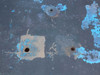 Close-up of table surface showing recessed mounting hardware inserts and bolt holes with surface wear