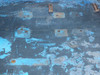 Top surface detail showing multiple raised mounting pads, bolt holes, and heavy surface wear with paint loss