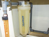 Close-up of Advantec filter housing showing translucent cylindrical filter body with blue Advantec label