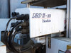 Yushin DRD II-HS robot arm close-up showing brand label and cable connections