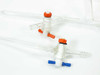 Close-up showing chipped and broken glass neck on a laboratory buret or tube — damage detail