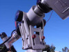 Upper arm pivot and camera bracket close-up showing tilt/rotate joints and red adjustment knobs
