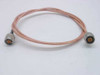 Times Fiber RG-142/U coaxial cable full length view showing both CDI N-male crimp connectors and pink braided jacket