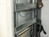 Xicom Technology rack cabinet — close-up of internal rack rails and mounting hardware with blue signal cable and IEC power cord routed along side panel
