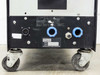 Eratron PPS 8210 RS MF – bottom rear view showing Eratron nameplate, multi-pin circular connector, two blue coolant port fittings, and heavy-duty casters