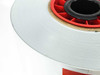 Close-up side view of Madico Protekt TFB backsheet roll edge showing white film layers on red spool
